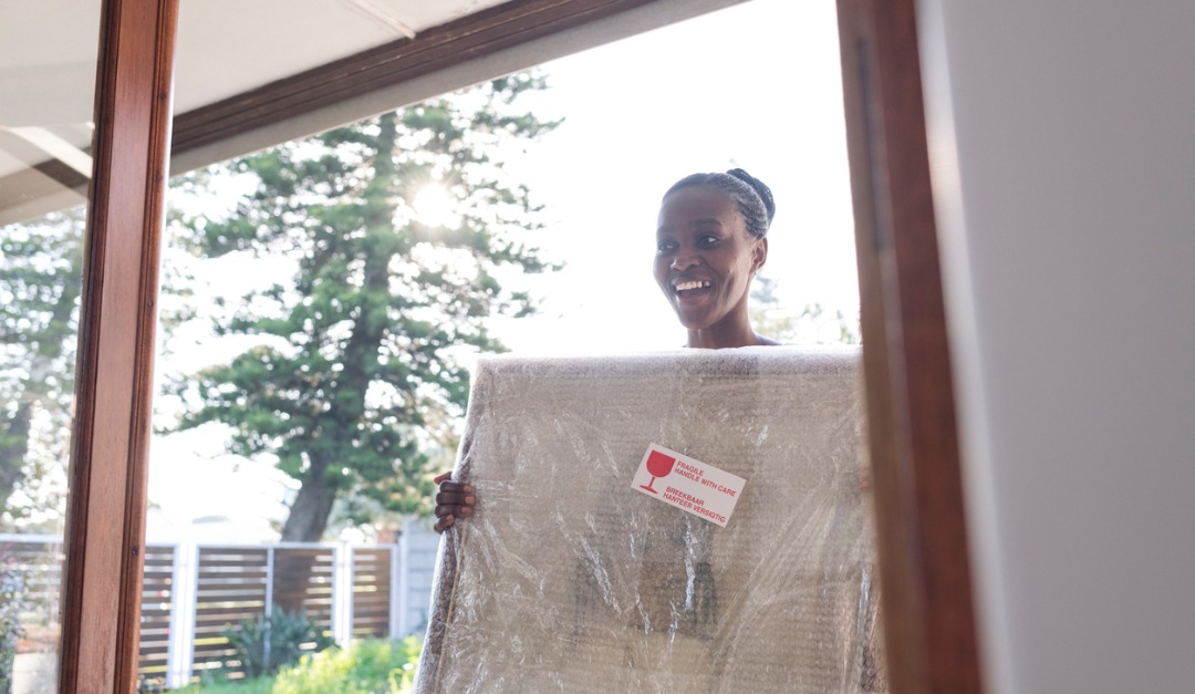 Woman Carrying A Cardbox with Fragile Sticker Attached on It