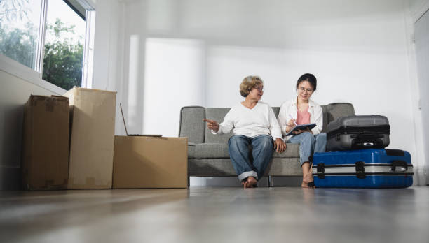 Moving Room and New House Concept, an Elderly Asian Woman Talks To Her Daughter About Cardboard Boxes Packing