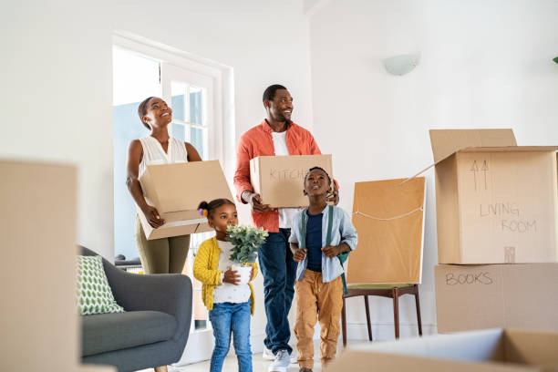 Beautiful African American family With Two Children Carrying Boxes Delivered by iMOVE NYC Crew Into Their New Home