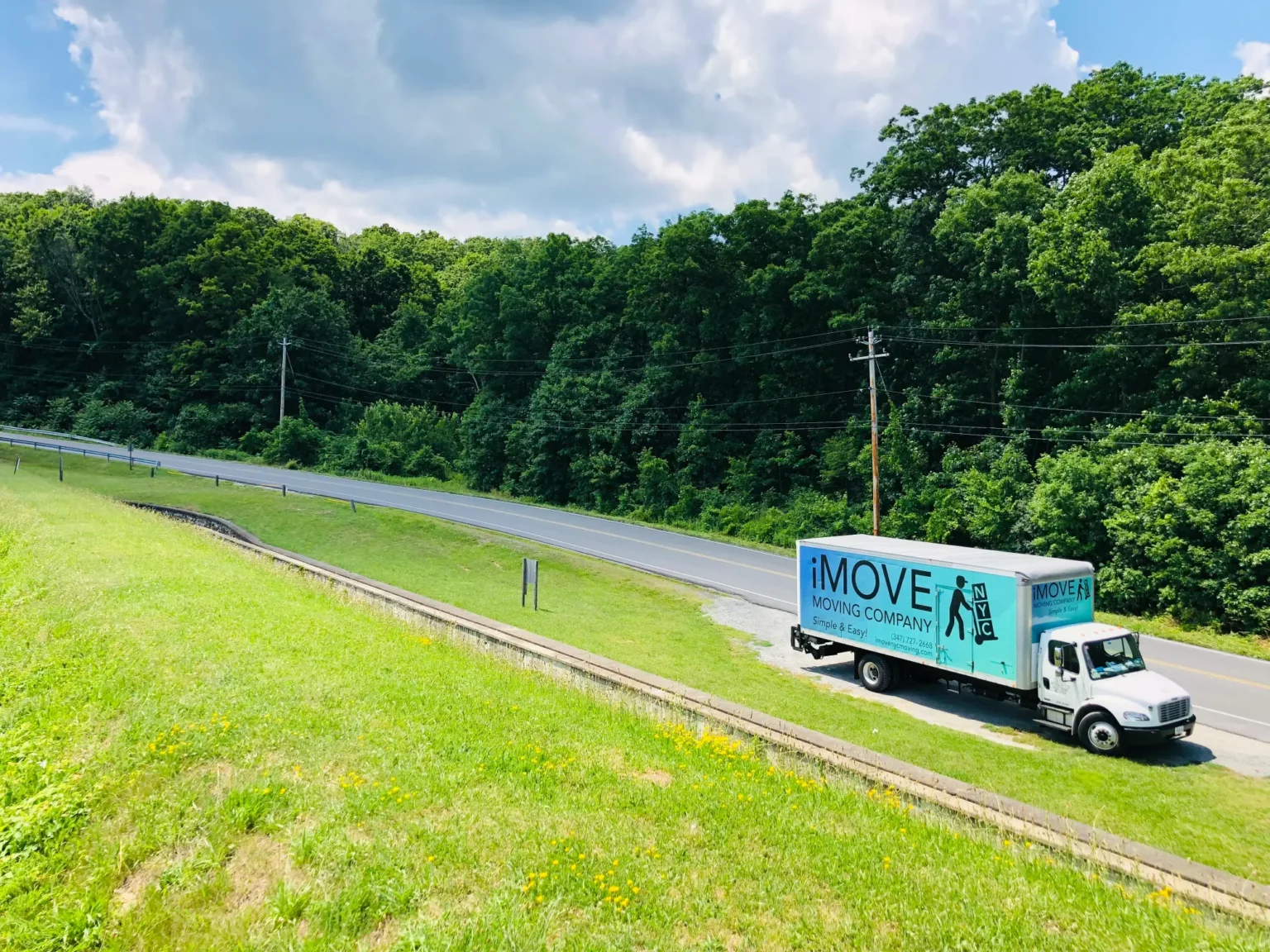iMOVE NYC Truck Parked By The Side Of The Road With Forrest Behind
